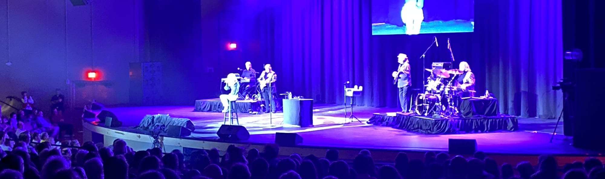 signer on stage in chair washed out by the lights Louisville